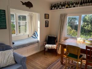 un soggiorno con tavolo, panca e finestre di Toad Hall a Baylys Beach