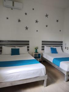 科蘇梅爾的住宿－Hermosa Casa Esencia en Cozumel，墙上星空间内的两张床