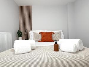 a bedroom with a white bed with an orange pillow at The Bohemian Basement in Kent