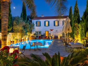 a villa with a swimming pool at night at Beyevi Alaçatı in Alaçatı