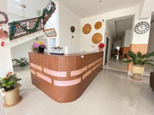 a lobby of a pharmacy with a counter and plants at Hotel Tonapa Prince Sorowako Mitra RedDoorz in Malili