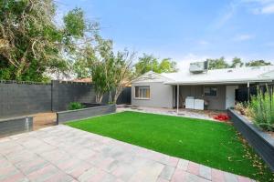 a house with a yard of green grass at Elsie House *great family spot* in Las Vegas