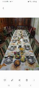 une longue table remplie de assiettes et de bols de nourriture dans l'établissement B&B Bahodir, à Samarcande