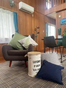 ein Wohnzimmer mit einem Stuhl und einem Eimer auf dem Boden in der Unterkunft 川平ハウス in Onna