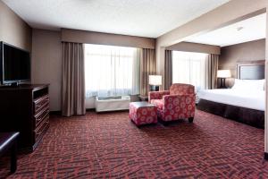 um quarto de hotel com uma cama e uma cadeira e uma televisão em Holiday Inn Express Hotel & Suites Cheyenne, an IHG Hotel em Cheyenne