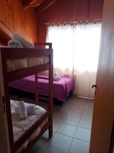 1 dormitorio con litera y ventana en Hospedaje de Ensueño SMA en San Martín de los Andes