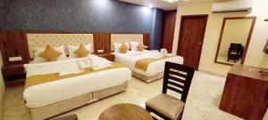 a hotel room with two beds and a mirror at Mayda Inn- A Boutique Hotel in New Delhi