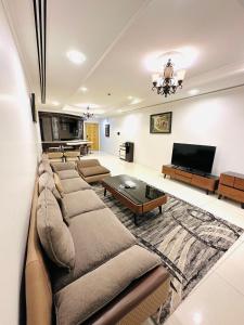 كييف تاوور للشقق الفندقية  في المنامة: غرفة معيشة مع كنب وتلفزيون بشاشة مسطحة
