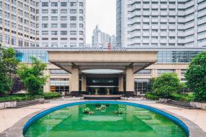 a large pool in front of a building with tall buildings at S&N Hotel Jiujiang in Jiujiang