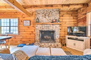 ein Wohnzimmer mit einem Steinkamin und einem TV in der Unterkunft Charming Lake Sinclair Cabin Fire Pit, Dock in Sparta