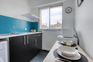 a kitchen with a table with plates on it at STUDIO SPA, CENTRE VILLE DE SANNOIS, PARKING PRIVE in Sannois