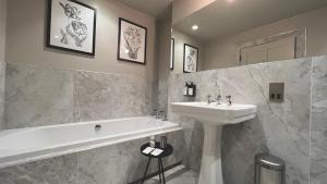 a bathroom with a sink and a bath tub and a sink at Leighton House - Boutique Guesthouse in Bath