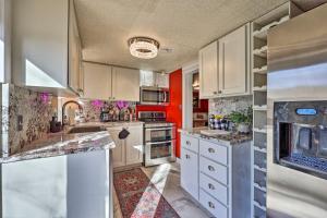 una cocina con armarios blancos y una pared roja en Vibrant Historic Home - Walk to Downtown!, en Eureka Springs