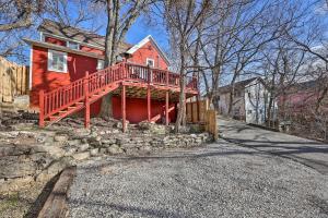una casa roja con una terraza a un lado. en Vibrant Historic Home - Walk to Downtown!, en Eureka Springs
