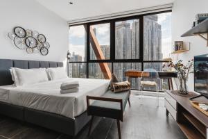 a bedroom with a bed and a desk and a large window at Scarletz KLCC Apartments by soulasia in Kuala Lumpur