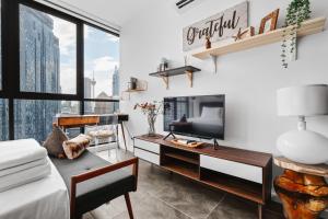 a living room with a large window and a tv at Scarletz KLCC Apartments by soulasia in Kuala Lumpur