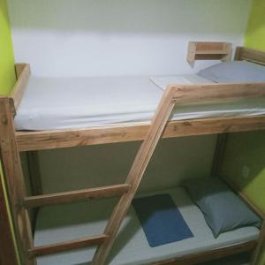 a bunk bed in a small room with a ladder at One Hostel - El Nido in El Nido