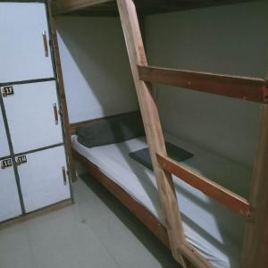 a room with two bunk beds and a door at One Hostel - El Nido in El Nido