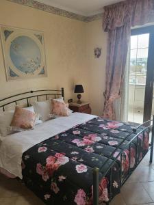 a bedroom with a bed with a floral bedspread and a window at Fiumicino River in Fiumicino