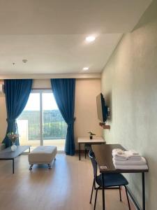 a living room with a table and a large window at On Hotel Friendship in Angeles