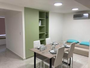 une salle à manger avec une table et des chaises blanches dans l'établissement Room in Apartment - Apartment Rodolfo Historic Center, à Mazatlán