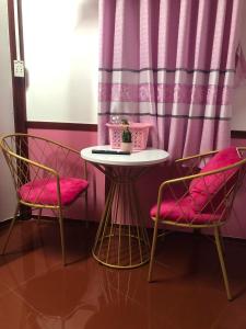 einem Tisch mit zwei Stühlen und einem Tisch mit einer Pflanze darauf in der Unterkunft Homestay Pink House (Ngôi nhà màu hồng) in Ấp Ðông Qứi