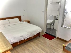 una camera con letto e un bagno con servizi igienici di Golden Station Homestay a Ta-wu-k'u