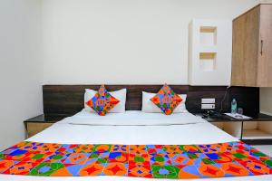 Una cama con una manta colorida encima. en FabHotel Regent Inn - Nr SkyWalk Bridge, en Pune