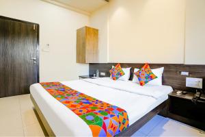 Un dormitorio con una cama grande con una manta colorida. en FabHotel Regent Inn - Nr SkyWalk Bridge, en Pune