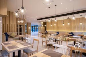 a restaurant with tables and chairs and lights at Orange Hotel Beijing Summer Palace in Beijing