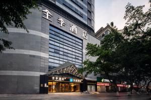 a tall building with a store in front of it at Hanting Hotel Chongqing Niujiaotuo Railway Station in Chongqing