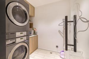 a laundry room with a washer and a dryer at Hanting Premium Hotel Xiamen Zhongshan Road Pedestrian Street in Xiamen