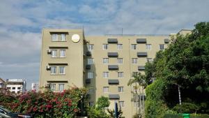 a tall yellow building with a clock on it at JI Hotel Xiamen University in Xiamen
