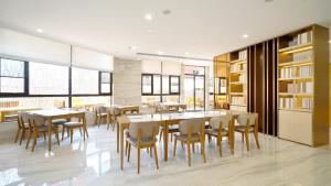 a dining room with tables and chairs and windows at JI Hotel Kunming Chenggong Chunrong Street Subway Station in Kunming