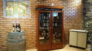 a wine cellar with a barrel and a cabinet with wine bottles at Casa Quinta da Adega do Chão - Vale do Douro in Lamego