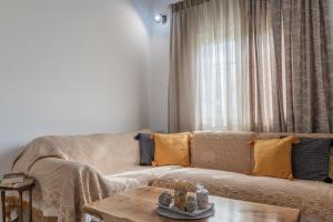 ein Wohnzimmer mit einem Sofa und einem Couchtisch in der Unterkunft Armando Cottage in Pandokrátor