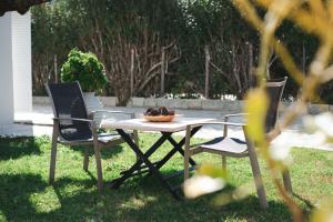 una mesa de picnic con dos sillas y un plato de comida. en Armando Cottage en Pandokrátor