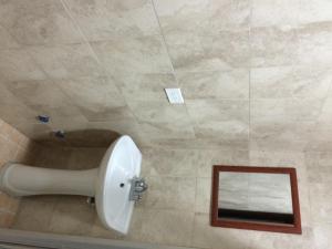 baño con urinario y espejo en Residencial Turístico El Descanso, en Panamá