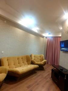 sala de estar con sofá y TV en Срочно Сдаётся!!!, en Tiflis