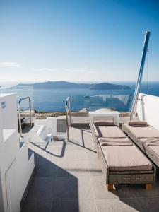 a balcony with chairs and a view of the ocean at Vitsentzos Suites in Imerovigli