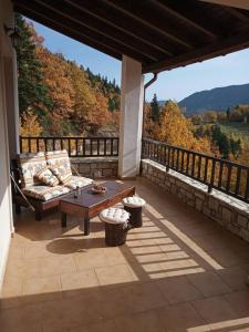 a patio with a couch and a table on a balcony at Evilion Traditional Inn in Plakotón