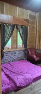 a purple bed in a room with a window at Talaga Tomohon Home Stay and Fishing Pond in Tomohon