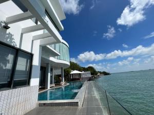 a building with a swimming pool next to the water at Nancy Grand Villa seaview 2 in Vung Tau