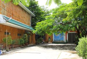 un patio de un edificio con árboles y plantas en GG Sweet Home en Mae Sot