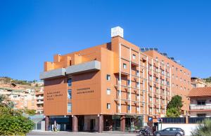 um grande edifício laranja numa rua da cidade em Hotel Macià Real De La Alhambra em Granada