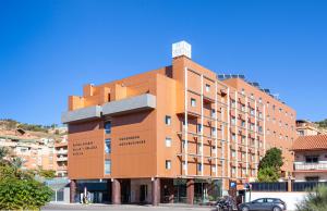 un grande edificio arancione su una strada cittadina di Hotel Macià Real De La Alhambra a Granada