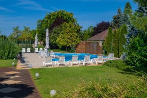 a group of chairs sitting next to a swimming pool at Hotel Kiss in Tata