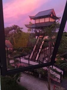 Blick auf eine Pagode aus dem Fenster in der Unterkunft Homestay Pink House (Ngôi nhà màu hồng) in Ấp Ðông Qứi