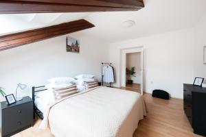 a white bedroom with a white bed and wooden floors at Prague - Karlin Apartments in Prague