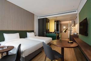 a hotel room with a bed and a table and chairs at S&N Yiting Hotel Taizhou in Taizhou